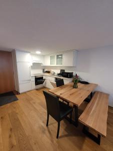 eine Küche mit einem Holztisch sowie einem Tisch und Stühlen in der Unterkunft Waibel Appartement Bezau in Bezau