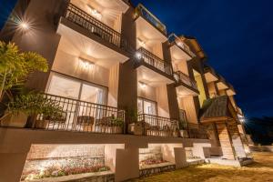 a building with lights on the side of it at Mountoria Retreat Bhimtal- by Leisure Hotels Group in Bhīm Tāl