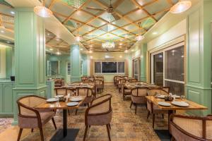 a dining room with wooden tables and chairs at Mountoria Retreat Bhimtal- by Leisure Hotels Group in Bhīm Tāl