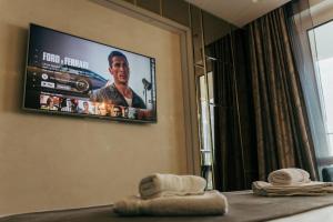 a tv on the wall in a hotel room at Luxury apartment in Central Park Burgas with amazing view + private parking space in Burgas City