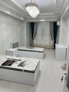 um quarto com 2 camas e um lustre em Mega house em Bukhara