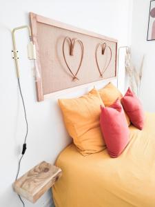 1 dormitorio con 1 cama con 2 corazones en la pared en Le Cosy Valcros, design et confort, en Aix-en-Provence