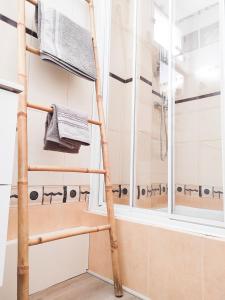 La salle de bains est pourvue d'une douche et d'une échelle en bambou. dans l'établissement Le Cosy Valcros, design et confort, à Aix-en-Provence