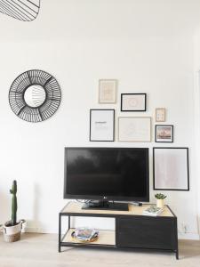 a living room with a tv on a table at Le Cosy Valcros, design et confort in Aix-en-Provence +40 photos
