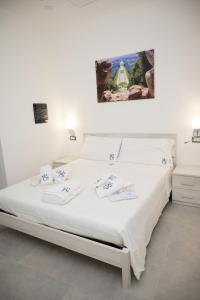 a white bed in a bedroom with a painting on the wall at B&B Smart Station Caserta in Caserta