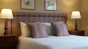 a bedroom with a bed with pillows and two lamps at The Red Lion Eaton in Norwich