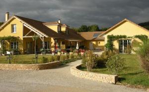 a yellow house with a landscaping in front of it at Le Clos des 4 Saisons in La Rochepot