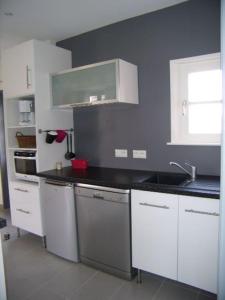 a kitchen with white cabinets and a black counter top at Aux couleurs de la Baie à Sailly-Bray in Noyelles-sur-Mer +37 photos