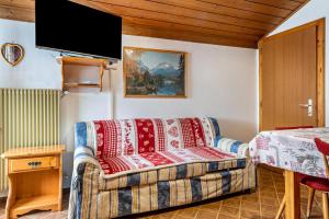 ein Wohnzimmer mit einem Sofa und einem Flachbild-TV in der Unterkunft Samont Appartment 5 in Arabba