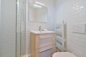 Un baño con inodoro, lavabo y espejo. en Welcome to the green House, en Marly-le-Roi