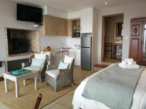 Una sala de estar con una cama y una cocina. en Lavandula Manor Self-Catering, en Mossel Bay