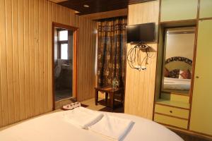 a bedroom with a bed and a tv on a wall at Hotel Sita Inn in Shimla