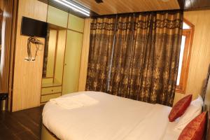 a small bedroom with a bed and a window at Hotel Sita Inn in Shimla