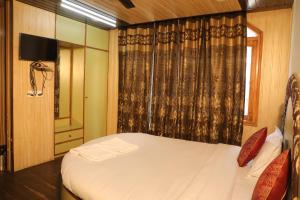 a bedroom with a white bed and a window at Hotel Sita Inn in Shimla