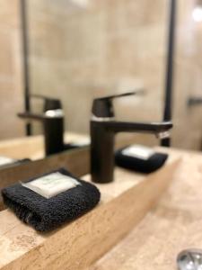 Un lavabo de baño con una toalla negra sobre un mostrador. en Panoramic - Magnifique T3, Climatisé avec Parking, en Sète