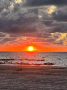 a sunset on the beach with the sun setting at Luxury home in quiet neighbourhood near beach in The Hague