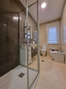 ein Bad mit einer Dusche, einem WC und einem Waschbecken in der Unterkunft VibesCoruña - Ángel 72 in A Coruña
