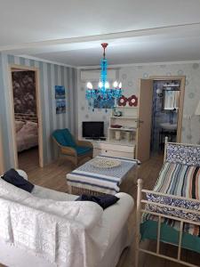 un soggiorno con divano e lampadario pendente di Olympus Miracle a Limín Litochórou