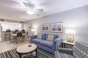 sala de estar con sofá azul y mesa en Surfside II #109 home, en Coffeyville