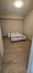 1 dormitorio con 1 cama y suelo de madera en Apartamento Centro do Mindelo 6 min da praia, en Mindelo