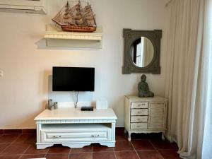 a living room with a tv and a dresser with a tvicter at Vida Boka in Donja Kostanjica