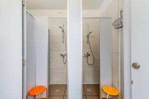 2 cadeiras cor-de-laranja na casa de banho com um chuveiro. em Art&Comfort Country em Kaunas
