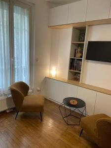 un salon avec une chaise et une table dans l'établissement Studio Paris tour Eiffel, à Paris 7 autres photos