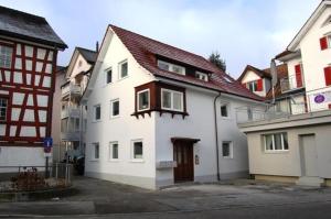 a white house with a red roof at London Apartments in Rheineck