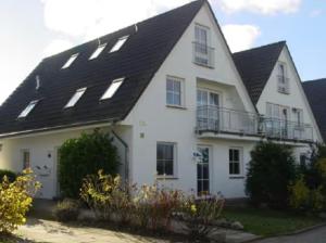 a white house with a black roof at Ferienwohnung Frische Brise in Drewoldke