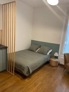 - une chambre avec un lit doté d'une tête de lit verte dans l'établissement Studio Paris tour Eiffel, à Paris