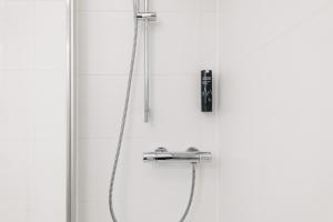 a shower with a hose and a shower head at Homaris Apartments Frankfurt in Frankfurt