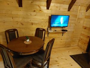 a dining room with a table and a television in a cabin at Sicevacka Bajka in Niš