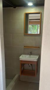 a bathroom with a sink and a mirror at Coco Beach in El Paredón Buena Vista