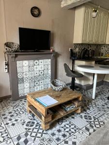 ein Wohnzimmer mit einem Couchtisch und einer Küche in der Unterkunft Gîte Pierre et Meuse in Fumay