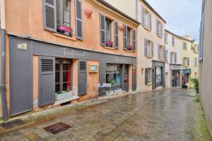 una calle vacía en una ciudad con edificios en Welcome To The Lola House, en Marly-le-Roi