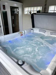 eine Badewanne mit blauem Wasser im Bad in der Unterkunft Studio avec sauna et wifi a La Ferriere aux Etangs in La Ferrière-aux-Étangs