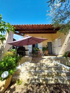 a patio with a table and an umbrella at Maison de charme à Autignac avec vue sur jardin et montagne in Autignac