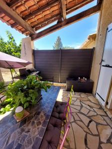 a patio with a fence and some plants at Maison de charme à Autignac avec vue sur jardin et montagne in Autignac