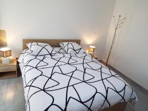 a bedroom with a black and white bed with two lamps at Maison de 2 chambres avec piscine partagee jardin clos et wifi a Avignon in Avignon