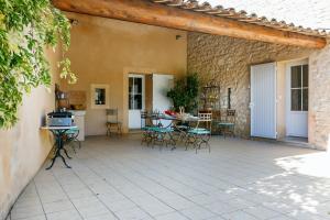 un patio con sedie e tavolo in un edificio di Villa de 4 chambres avec piscine privee jardin clos et wifi a Caromb a Caromb