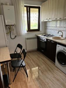 a kitchen with two chairs and a sink and a stove at Sweet Home Iasi Airport 2 in Iaşi