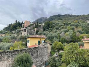 a town on a hill next to a stone wall at La dolce vita al lago in Bogliaco