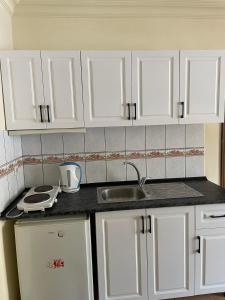 a kitchen with white cabinets and a sink at BEST HOUSE APART HOTEL-2 in Alanya