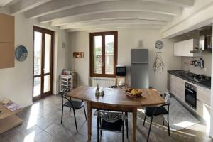a kitchen with a wooden table and chairs in a room at La dolce vita al lago in Bogliaco