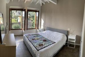 a bedroom with a bed and two windows at La dolce vita al lago in Bogliaco