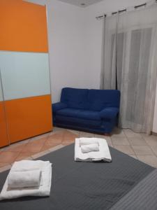 a living room with a blue couch and two towels at Casa Butera in Bagheria