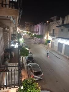 a city street at night with cars parked on the street at Casa Butera in Bagheria