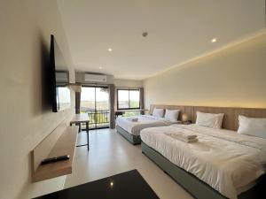 1 dormitorio con 2 camas y TV. en The Way Hotel Ban Pong, en Ban Pak Raet