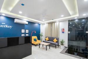 um átrio de escritório com uma parede azul e cadeiras amarelas em Hotel Blue Shine em Jaipur