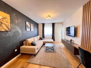 uma sala de estar com um sofá e uma televisão em White Homes 105 - Central Point em Podgorica